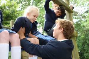 Older pupil supporting younger pupils at Holme Grange School